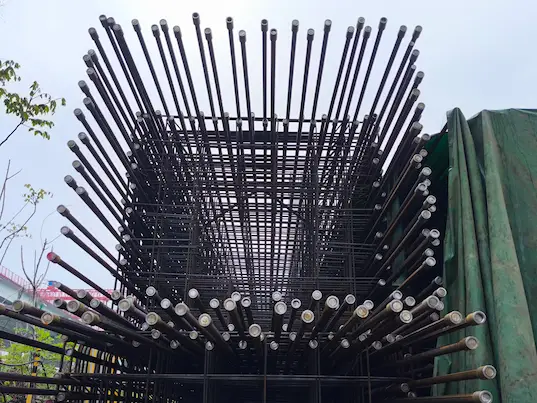 Mechanical rebar coupler connecting reinforcing bars in a rebar cage assembly